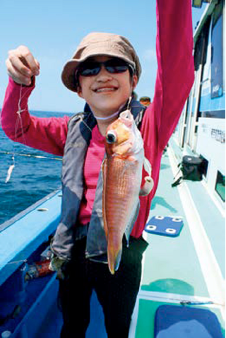 女の子がアマダイを釣り上げている写真