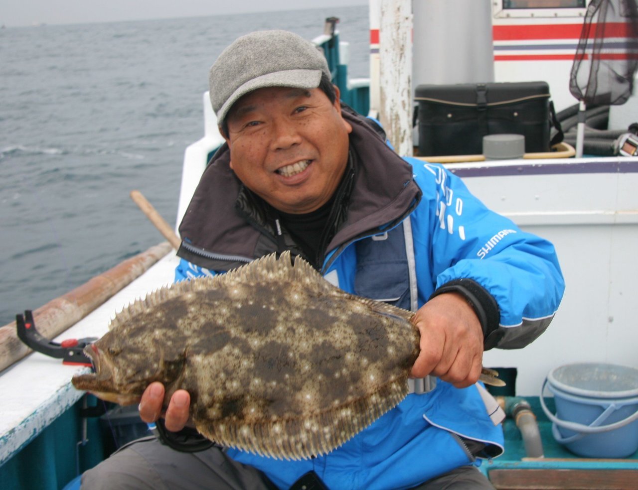 ヒラメを釣り上げた釣り人の写真