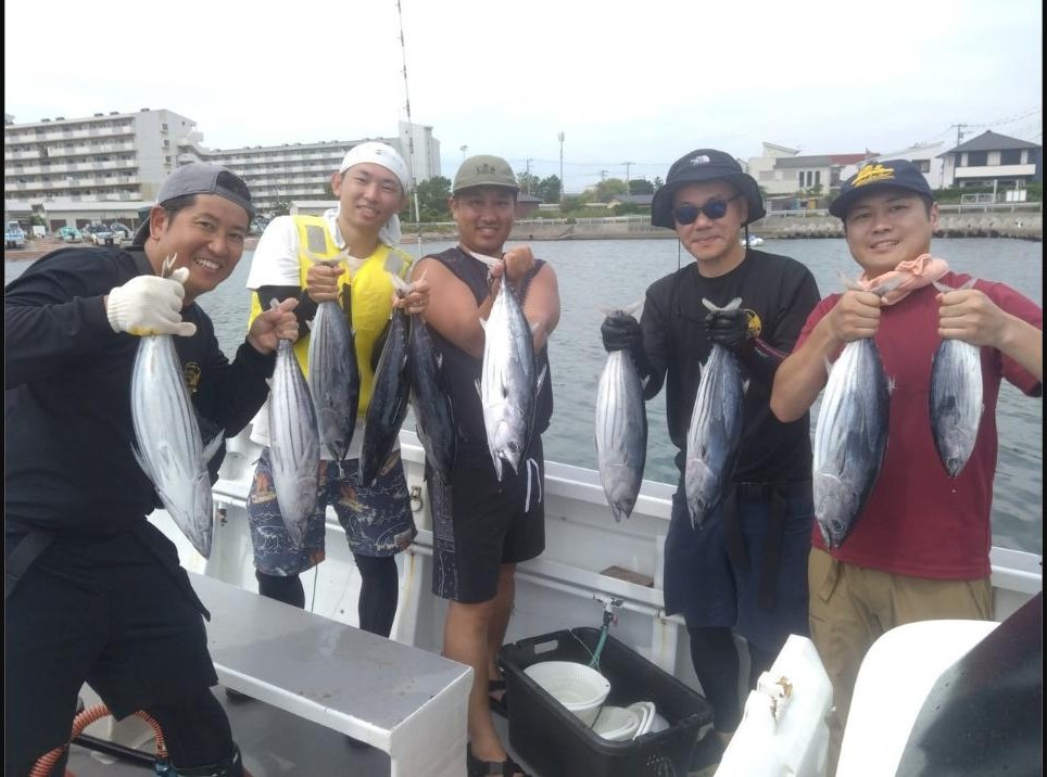 かねい丸で釣れたカツオを掲げる5人の乗船者