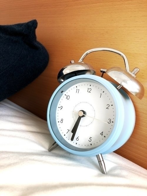目覚まし時計　ベッド　枕　写真