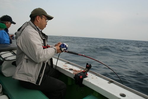 釣船　男性　釣り竿　リール　海　写真