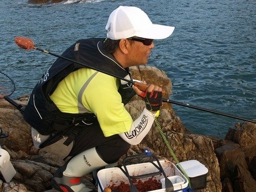 釣り人　男性　マキエサ　タモ　海　写真