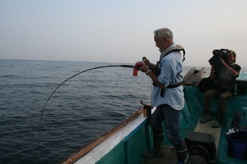 釣り人　男性　釣り竿　釣船　カメラマン　海　写真