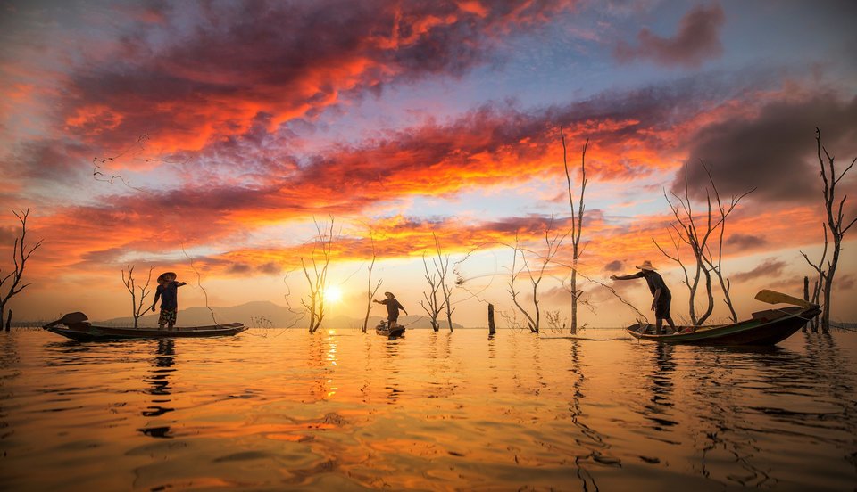 釣り人　ボート　網　夕日　海　写真