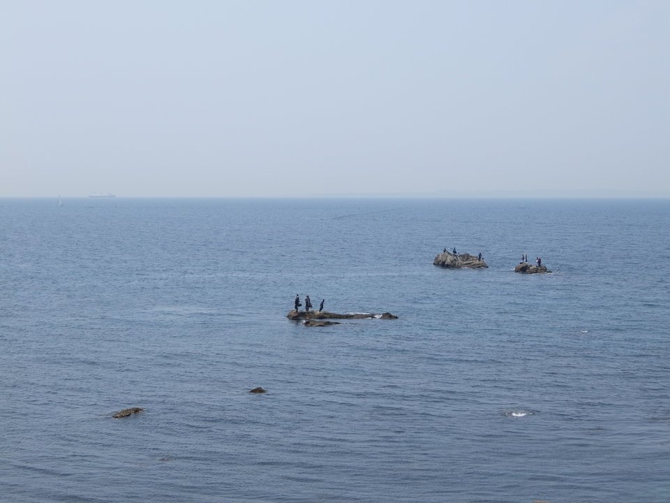 釣り人　岩場　海　空　写真