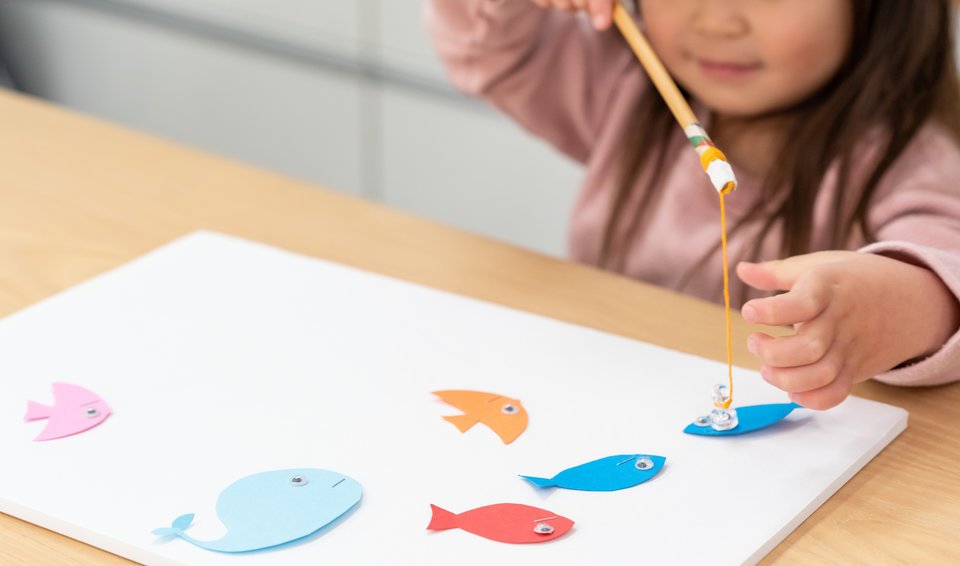 日本人　子供　女の子　魚釣りのおもちゃ　画用紙　写真