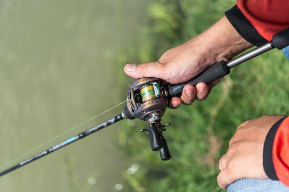 左ハンドルのベイトリールを持つ手