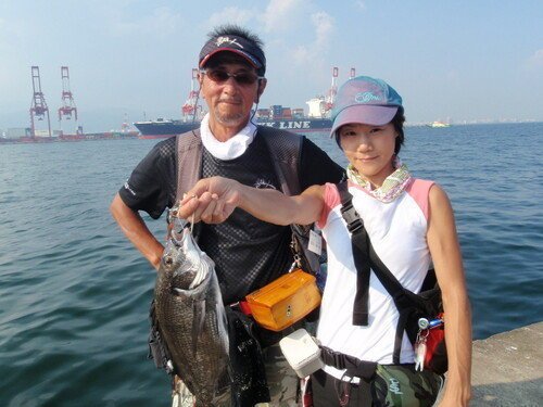 釣り人　男性　女性　クロダイ　海　空　貨物船　写真