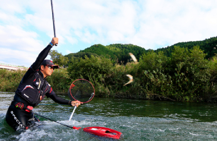 友釣りで鮎を釣り上げるアングラー