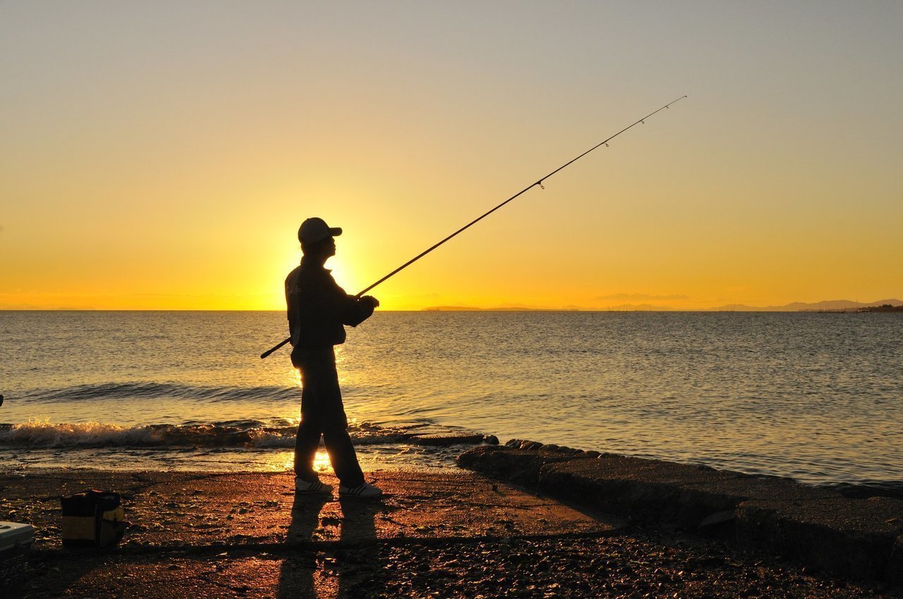 投げ竿と釣り人の写真