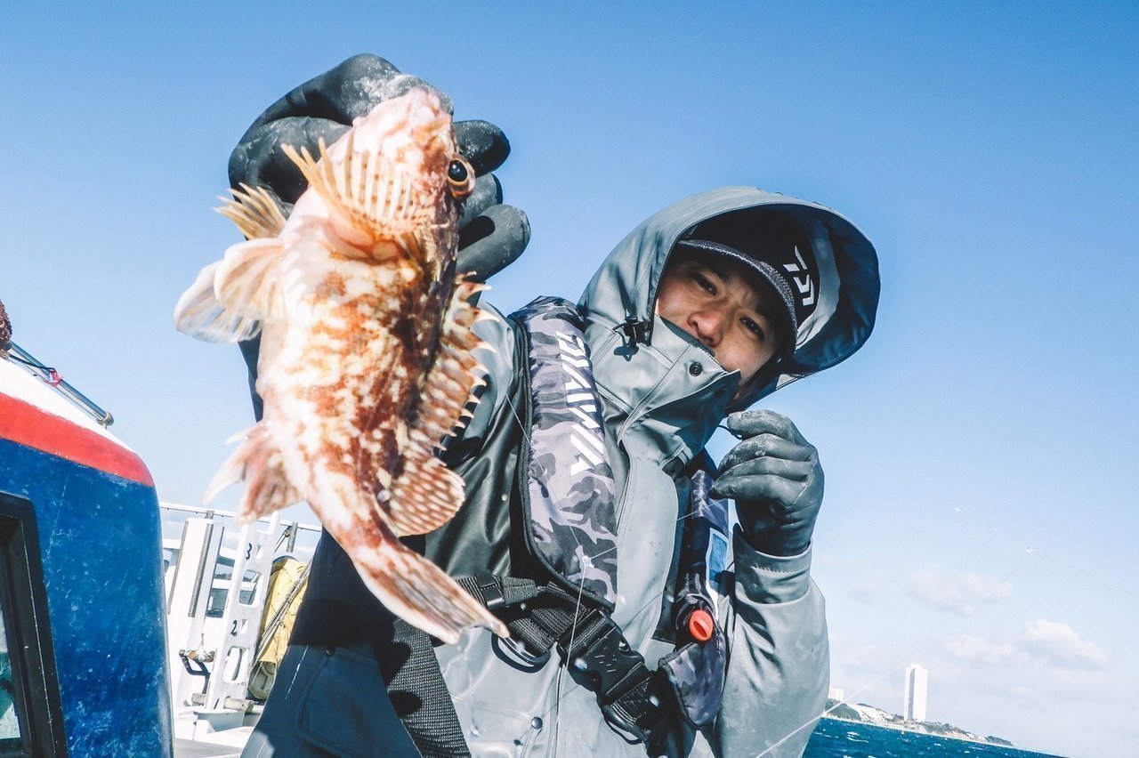 カサゴを持つ釣り人の写真