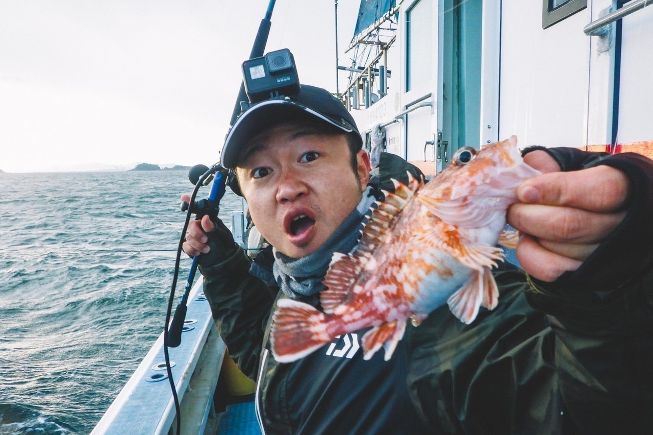 カサゴを持つ釣り人の写真
