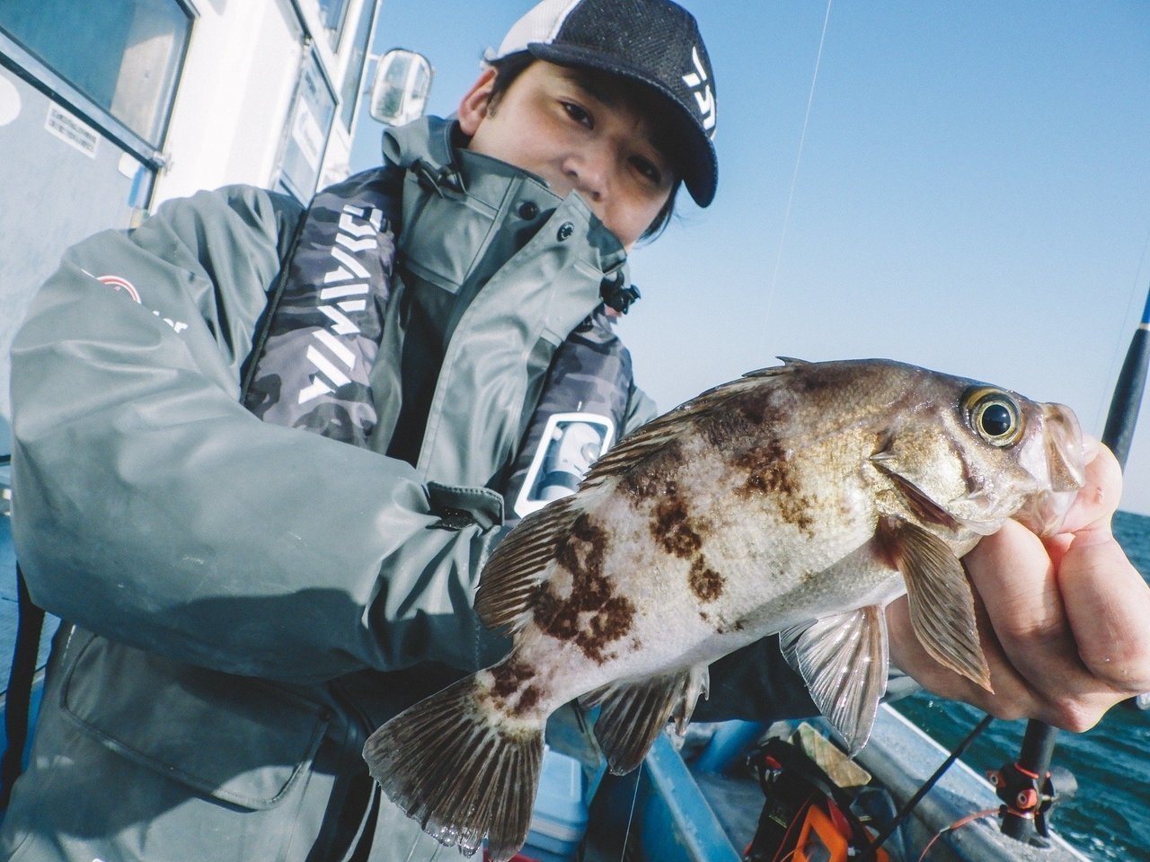カサゴを持つ釣り人の写真