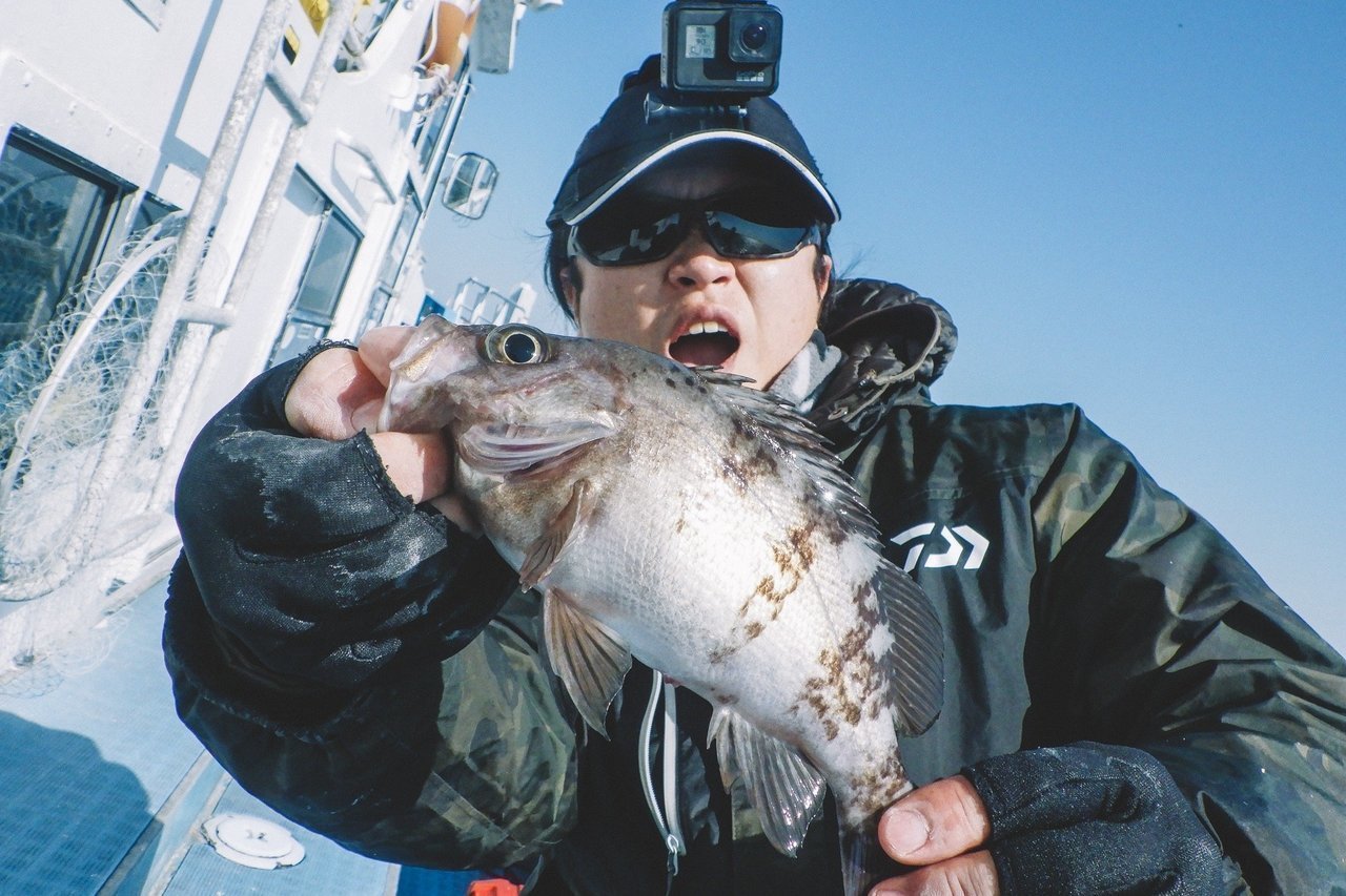 カサゴを持つ釣り人の写真