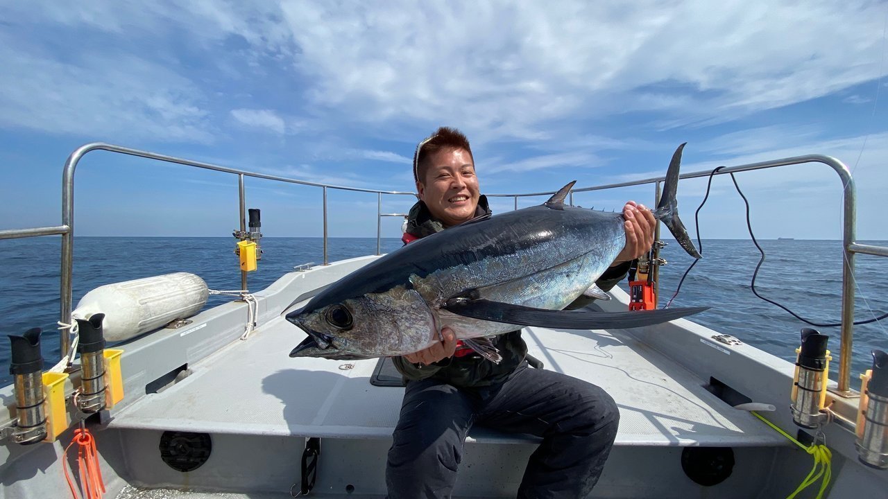 ビンチョウマグロを抱える釣り人の写真