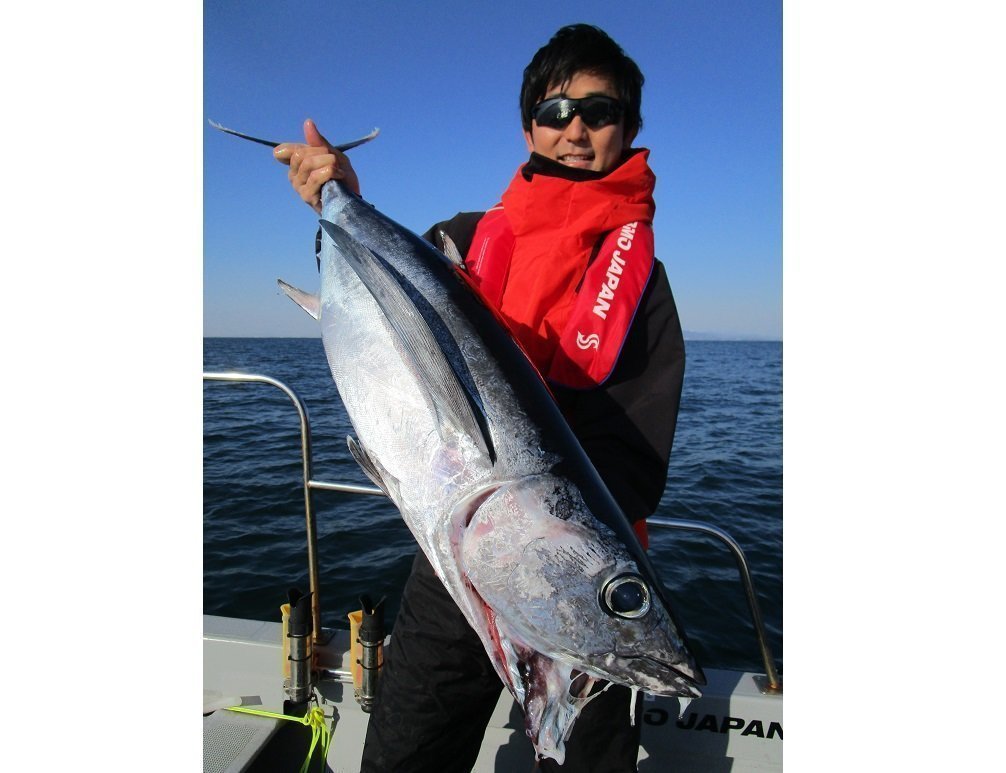 ビンチョウマグロを抱える釣り人の写真
