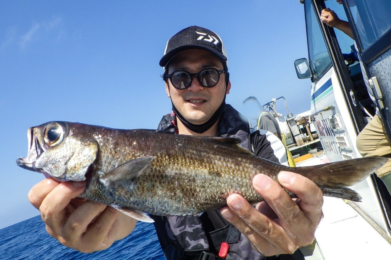 釣り人が魚を抱える写真