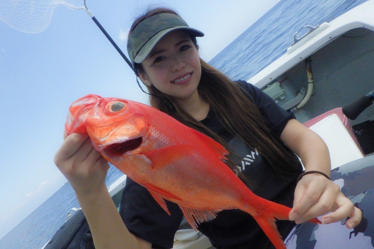 釣り人が魚を抱える写真