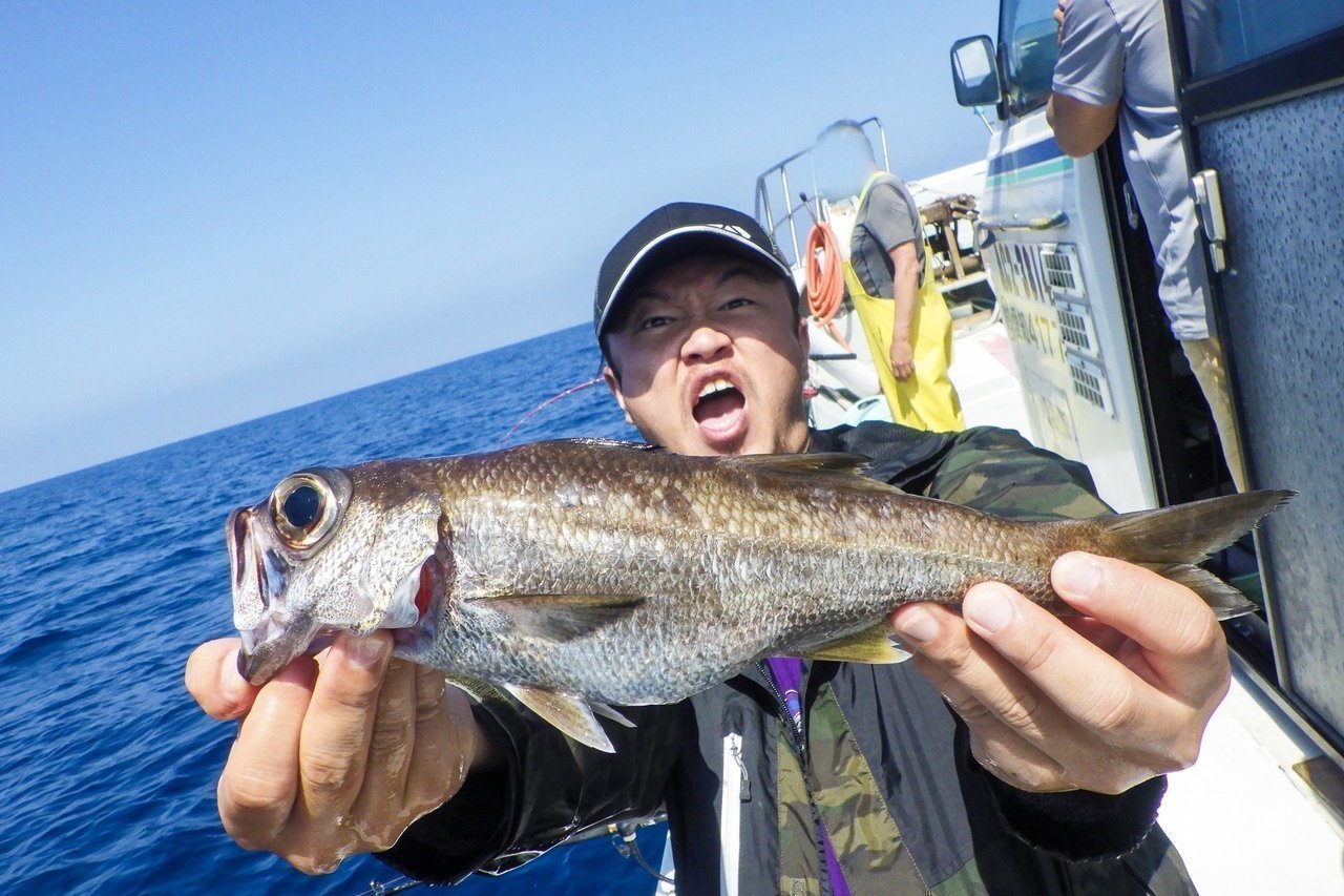 釣り人が魚を抱える写真