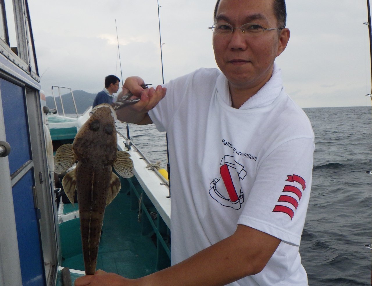 マゴチを釣り上げた男性の写真