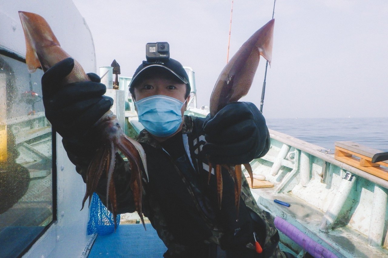 釣り人とスルメイカの写真