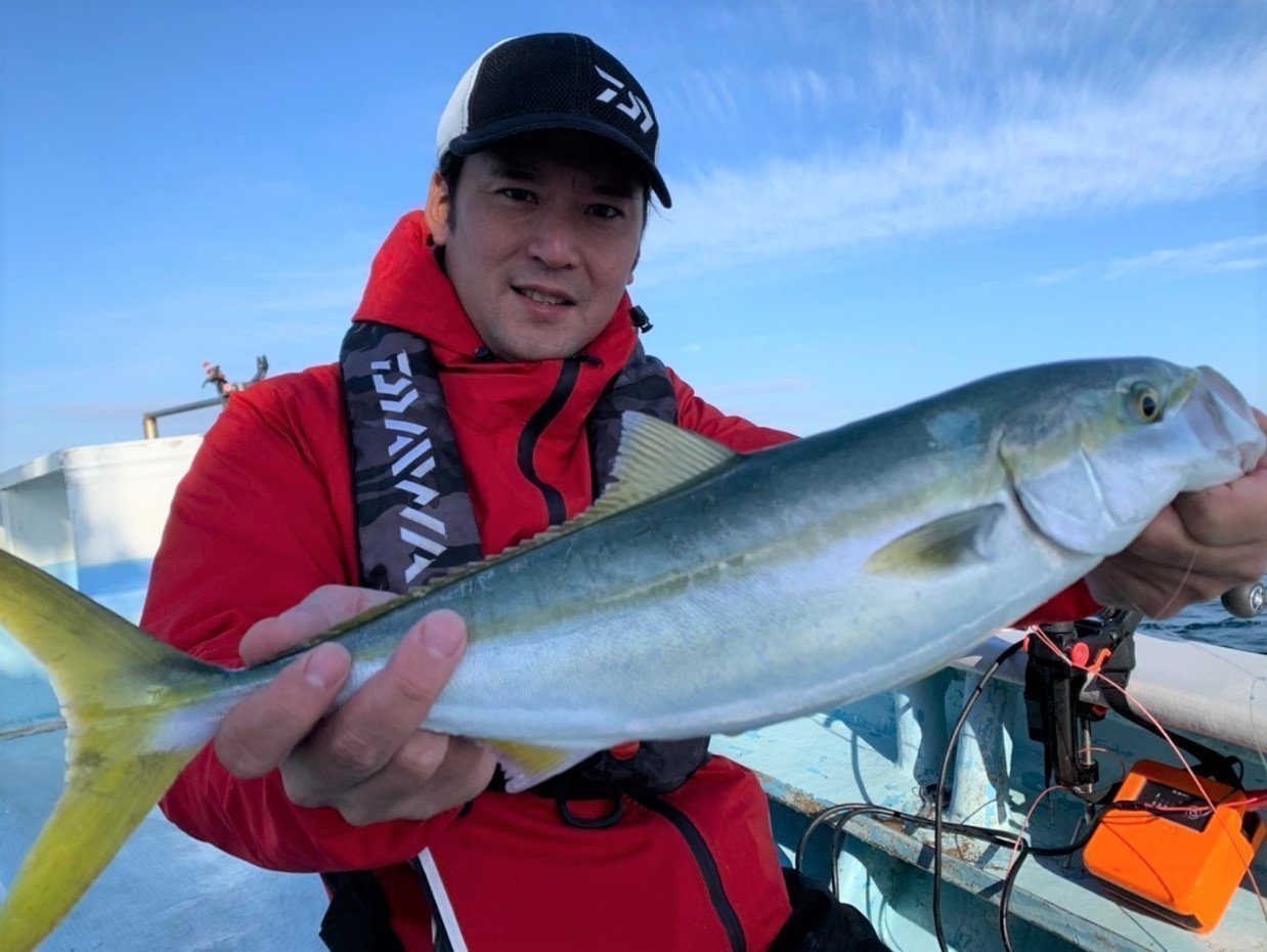 男性とハマチの写真