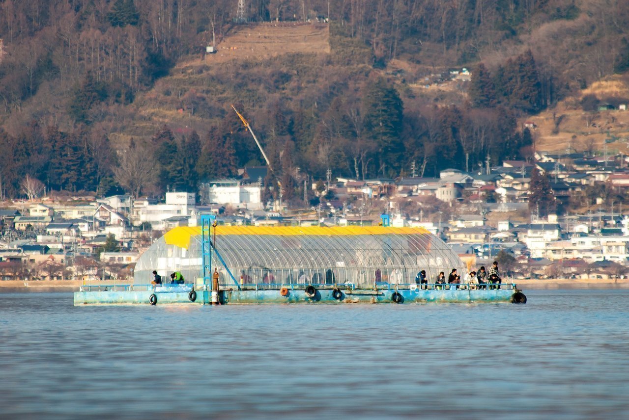 ドーム船でワカサギ釣りをする人々