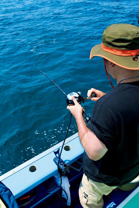 男性がリールを巻いている画像